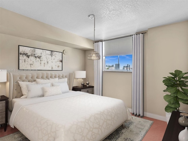 bedroom featuring baseboards and a textured ceiling