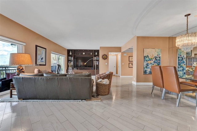 living room featuring baseboards, a chandelier, and wood finished floors