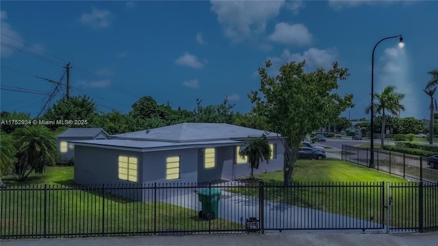 view of front of property with stucco siding, a gate, fence, and a front yard