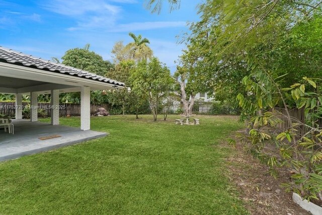 view of yard with fence and a patio