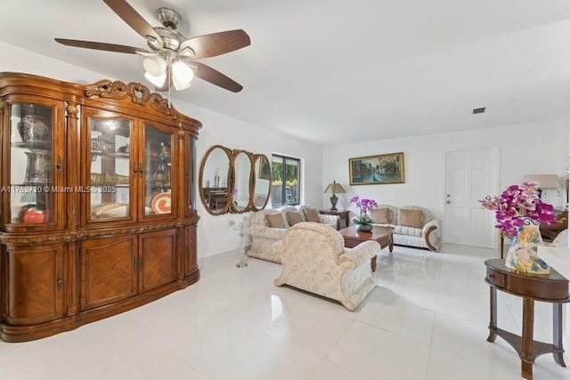 living area featuring baseboards, ceiling fan, and tile patterned floors