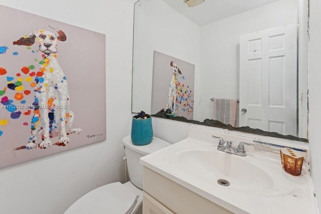 half bathroom with toilet, radiator heating unit, and vanity