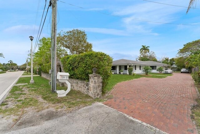 view of front of home featuring stucco siding, a tile roof, and decorative driveway