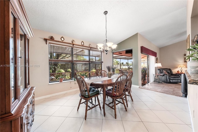 dining area featuring lofted ceiling, light tile patterned floors, a textured ceiling, and a notable chandelier