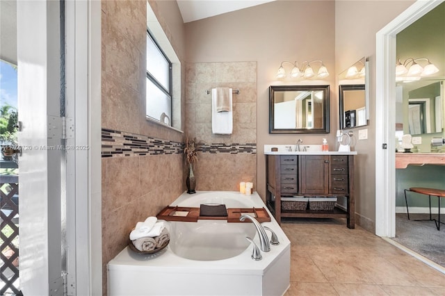 bathroom with lofted ceiling, tile patterned flooring, vanity, a bath, and tile walls