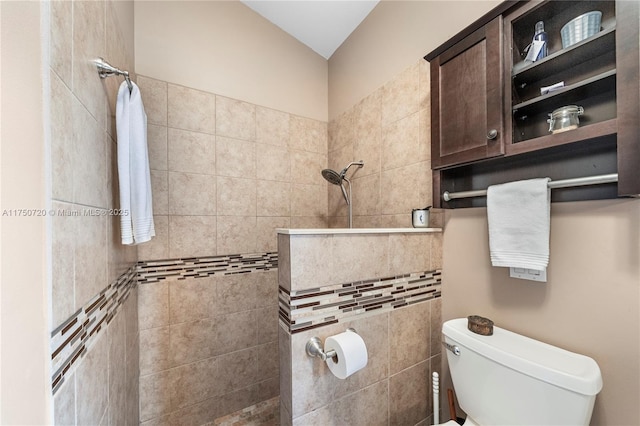 bathroom featuring a tile shower and toilet