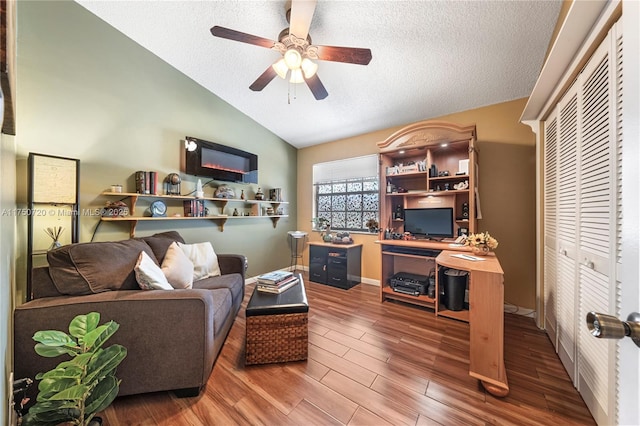 office space with lofted ceiling, ceiling fan, a textured ceiling, and wood finished floors