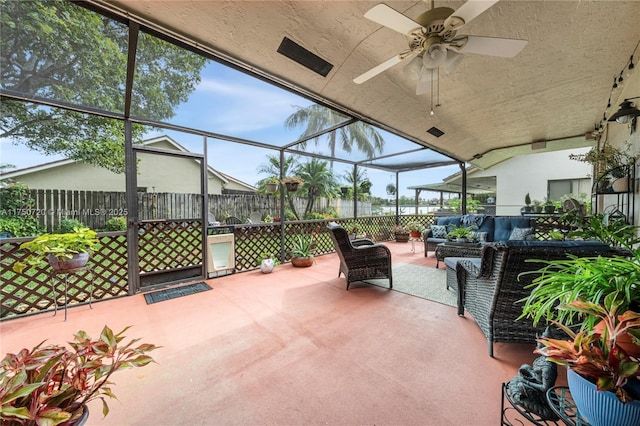 view of patio / terrace featuring glass enclosure, outdoor lounge area, fence, and ceiling fan