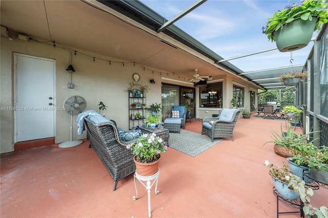 view of patio featuring a lanai, outdoor lounge area, and a ceiling fan