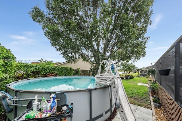 view of swimming pool with a yard, fence, and a fenced in pool