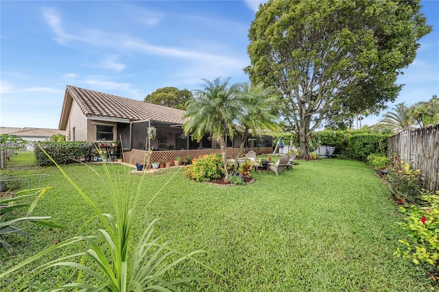 view of yard featuring a sunroom and a fenced backyard