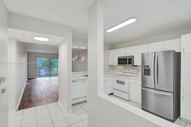 kitchen with light tile patterned floors, stainless steel appliances, light countertops, and white cabinetry