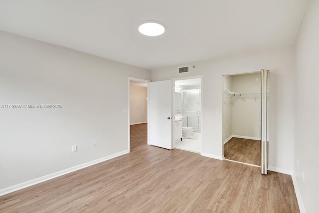 unfurnished bedroom with light wood-style floors, baseboards, visible vents, and a closet