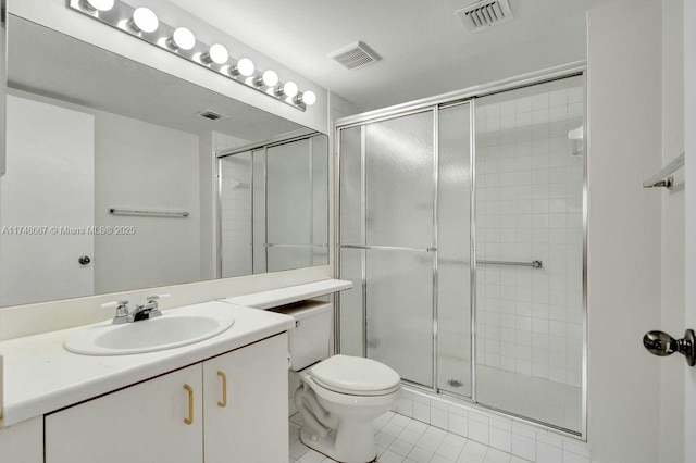 bathroom featuring toilet, a shower stall, and visible vents