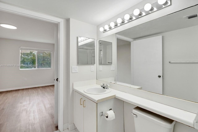 bathroom featuring vanity, wood finished floors, visible vents, and baseboards