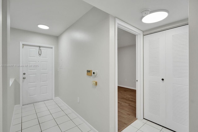 entryway featuring baseboards and light tile patterned flooring