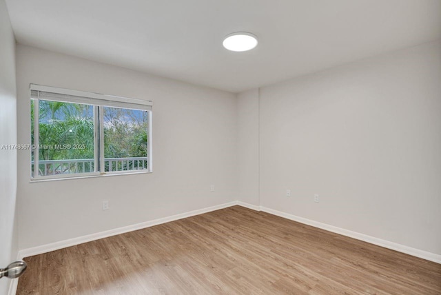 unfurnished room with baseboards and wood finished floors