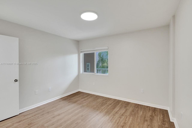 empty room with baseboards and wood finished floors