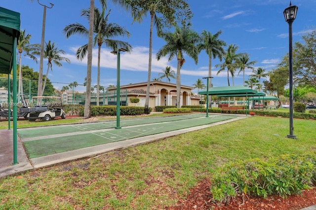 view of property's community featuring shuffleboard and a lawn