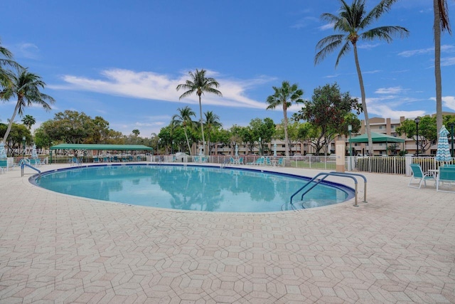 community pool with fence and a patio