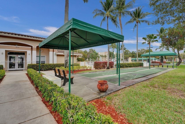 view of home's community with a yard and shuffleboard