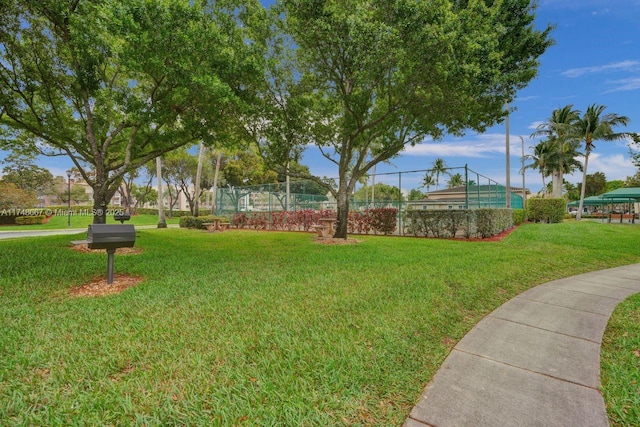 view of property's community with fence and a lawn