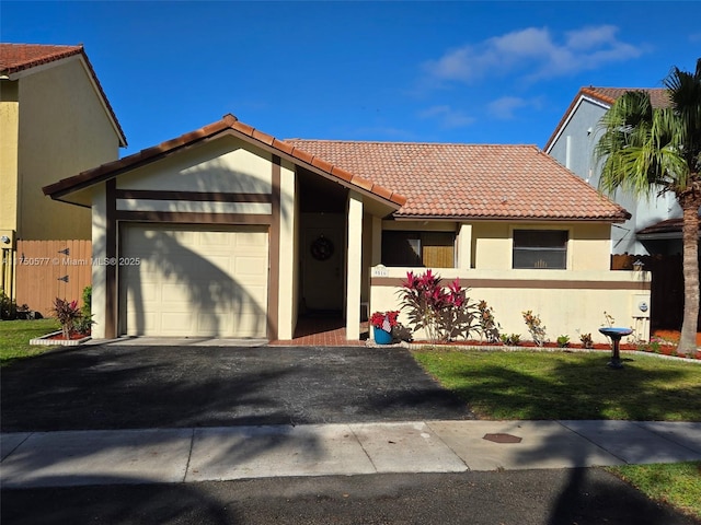 ranch-style house with a garage, a tiled roof, aphalt driveway, and stucco siding