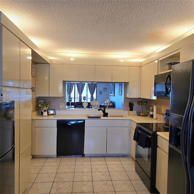 kitchen with light countertops, black appliances, and a textured ceiling