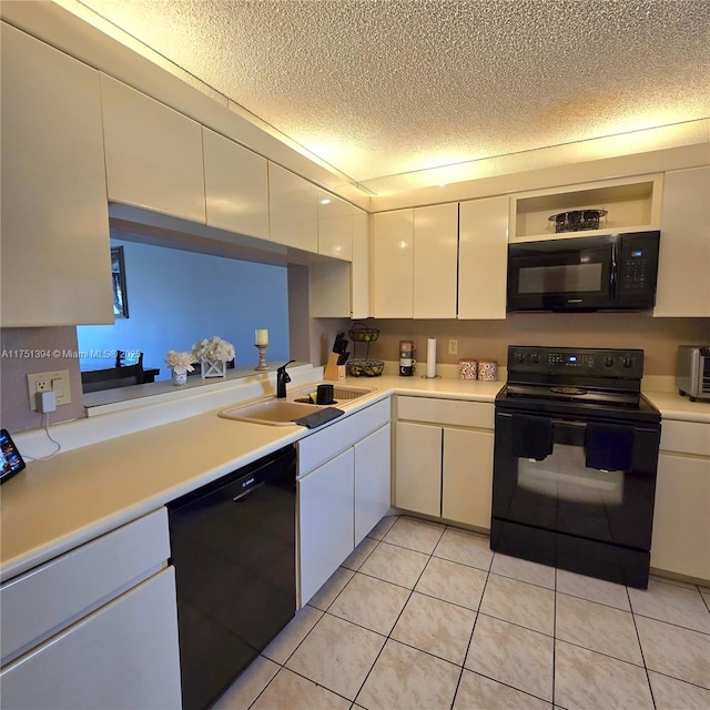 kitchen with a textured ceiling, white cabinets, black appliances, a sink, and light countertops