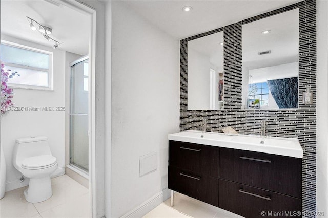 full bathroom featuring a stall shower, a sink, toilet, and decorative backsplash