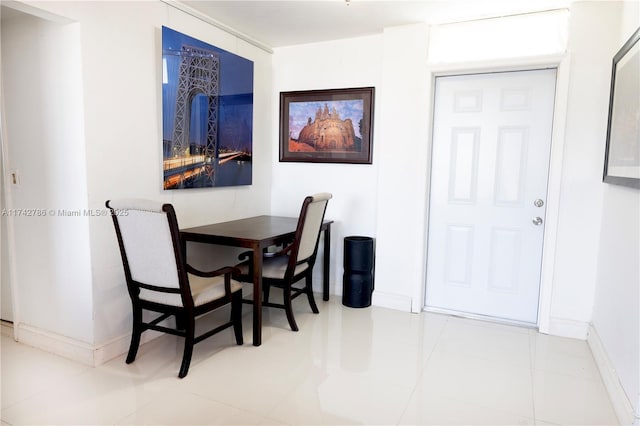 tiled dining room featuring baseboards