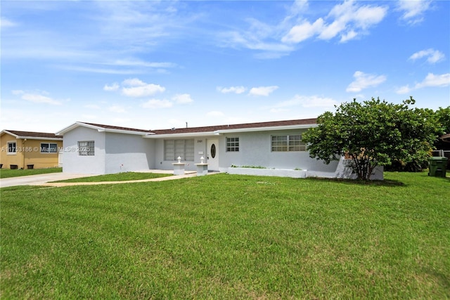 ranch-style house featuring a front lawn and stucco siding