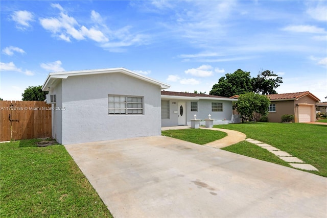 single story home featuring a front yard, concrete driveway, fence, and stucco siding