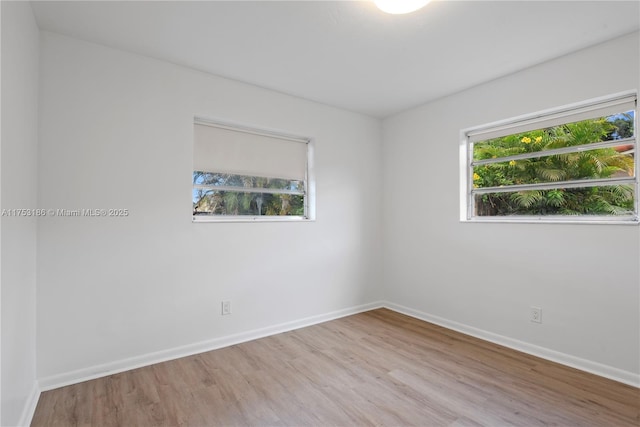 spare room featuring baseboards and wood finished floors