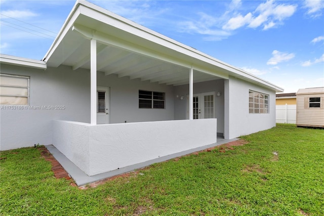 exterior space featuring stucco siding, fence, and a yard