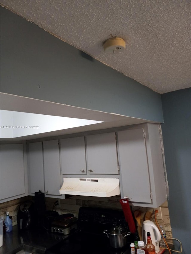 5868 NW 21st St Unit 45-C, Lauderhill, FL 33313 - detailed view of under cabinet range hood, black gas stove, and a smoke detector
