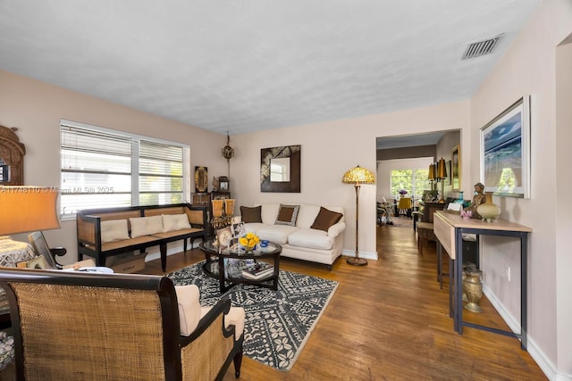 living area featuring wood finished floors, visible vents, and baseboards