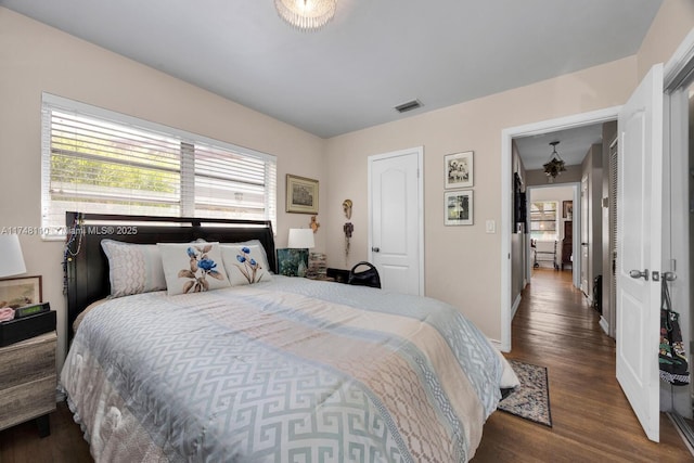 bedroom featuring visible vents, baseboards, and wood finished floors