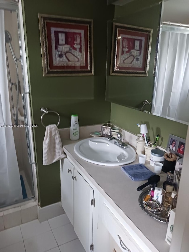 full bathroom featuring a stall shower, tile patterned flooring, and vanity