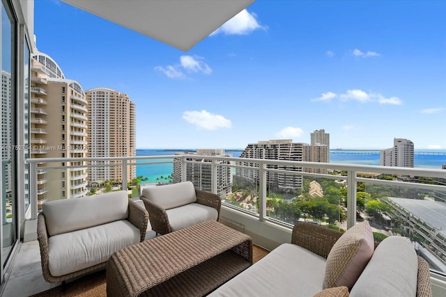 balcony with a water view, a view of city, and outdoor lounge area