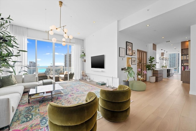 living area featuring a notable chandelier, wood finished floors, and recessed lighting