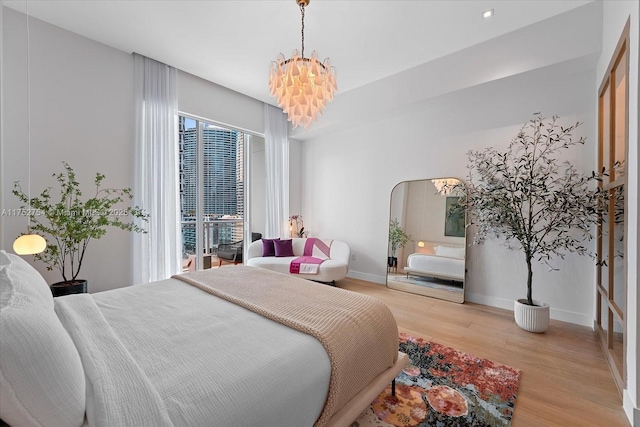 bedroom featuring arched walkways, baseboards, wood finished floors, and a chandelier