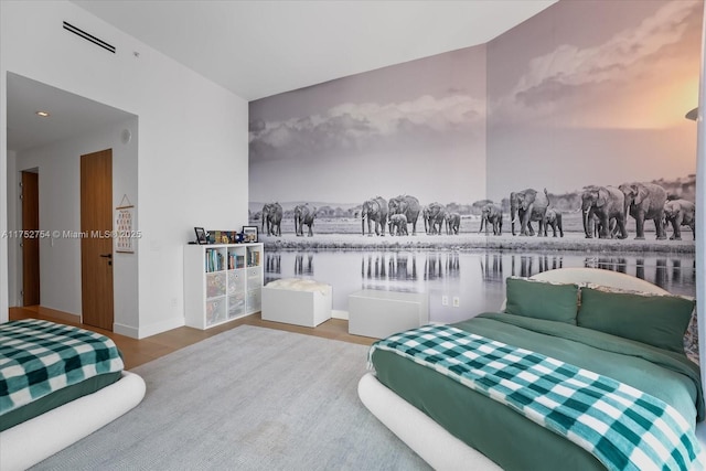 bedroom featuring wood finished floors, visible vents, and baseboards