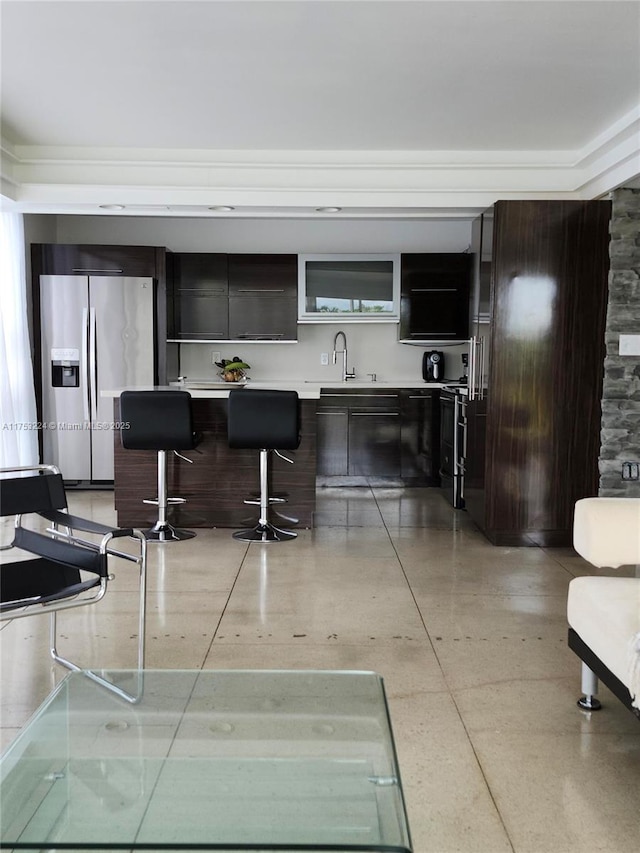 bar featuring a sink and stainless steel refrigerator with ice dispenser