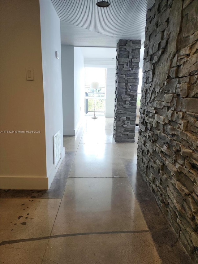 hallway with visible vents and baseboards