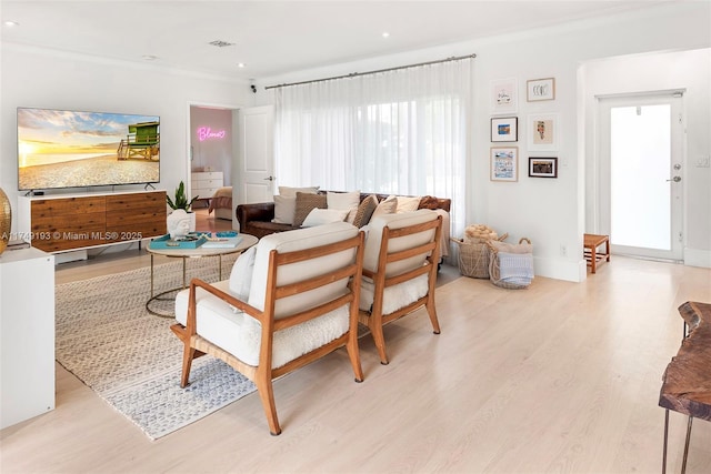 living room featuring recessed lighting, visible vents, ornamental molding, light wood-type flooring, and baseboards