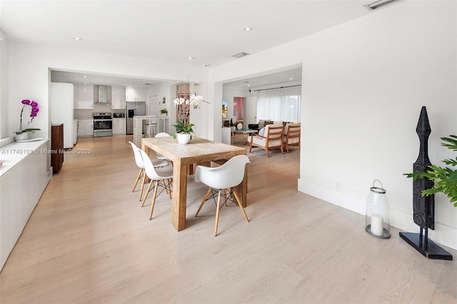 dining space featuring baseboards, recessed lighting, and light wood-style floors