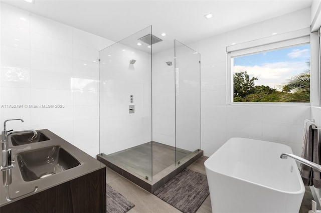 641 NW 7th St Rd, Miami, FL 33136 - full bathroom featuring a sink, a soaking tub, a shower stall, and tile walls