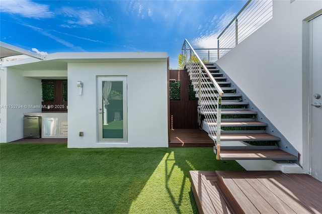 641 NW 7th St Rd, Miami, FL 33136 - back of house with stairway, a deck, a lawn, and stucco siding