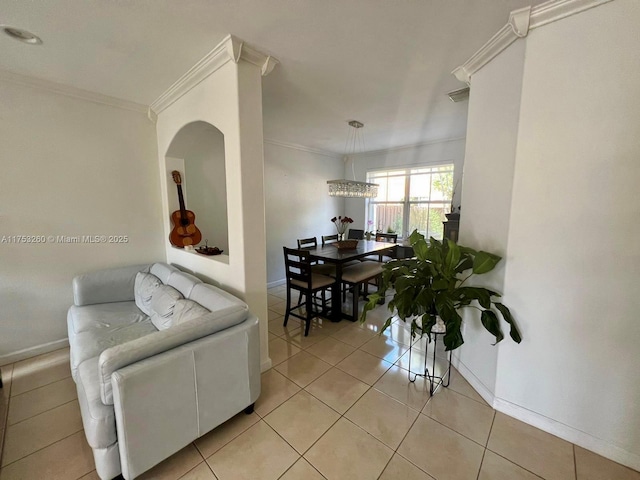 living area featuring light tile patterned floors, baseboards, and crown molding